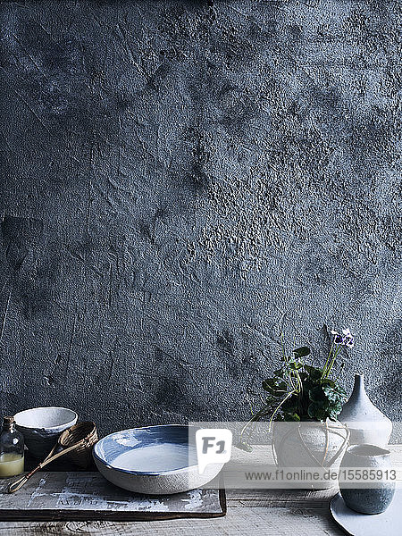 Ceramic bowls and vases against background of unfinished wall