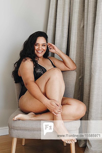 Woman in lingerie posing on chair in room