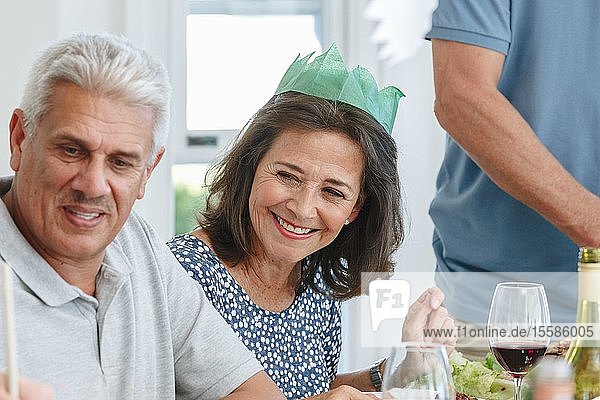Älteres Ehepaar lauscht aufmerksam am Esstisch in der Hausparty