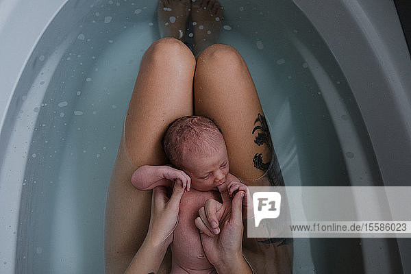 Mutter mit kleinem Sohn auf dem Schoß in der Badewanne  Draufsicht beschnitten