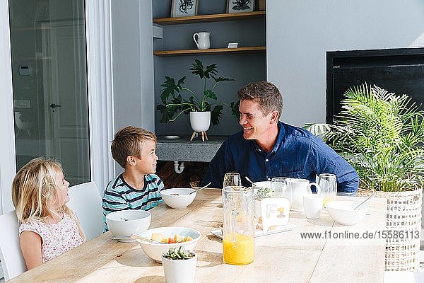 Father talking with children during lunch at home