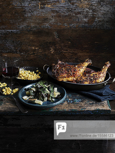 Rustic still life with chipotle chicken corn and rainbow chard on wooden table