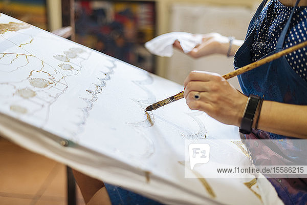 Junge Frau übt Batik im Kunstunterricht  eine traditionelle Form der indonesischen Malerei  Schnittansicht der Hände