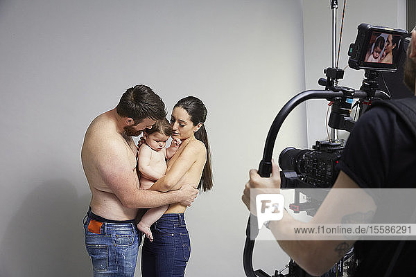 Photographer taking portrait of couple and baby girl