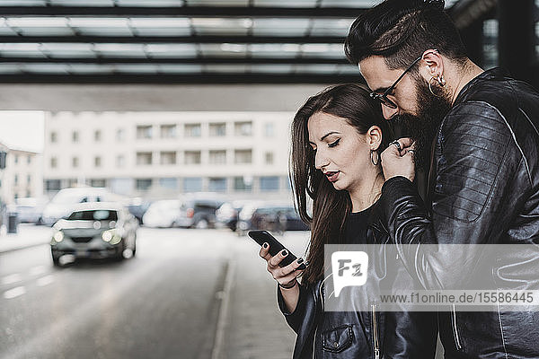 Ehepaar mit Smartphone außerhalb der Station