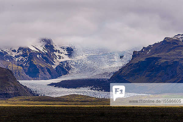 Schneebedeckte Berglandschaft mit Gletscher und niedrigen Wolken  Skaftafell  Austur-Skaftafellssysla  Island