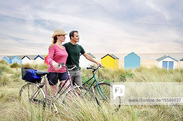 Paar mittlerer Erwachsener mit Fahrrädern an der Küste  Southwold  Suffolk  UK