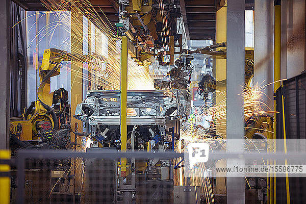 Robots welding steel car body in car factory
