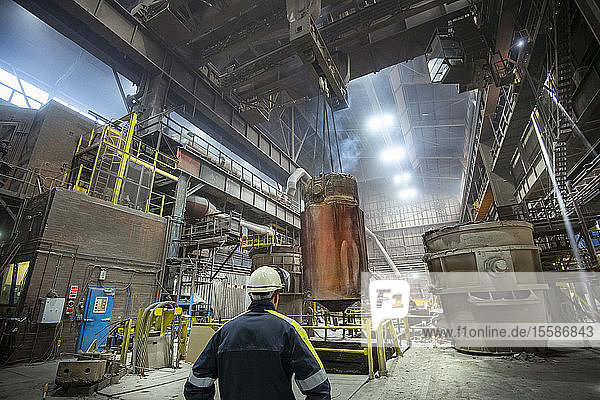 200 ton red hot steel ingot being lifted from mould in steelworks