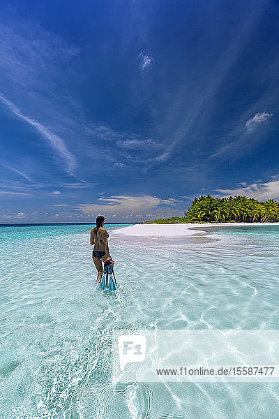 Woman with snorkelling gear on tropical beach  The Maldives  Indian Ocean