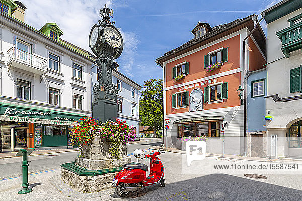 View of colourful buildings  red scooter and main street in Bad Aussie  Styria  Austria