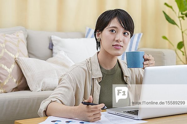 Junge japanische Frau bei der Arbeit zu Hause