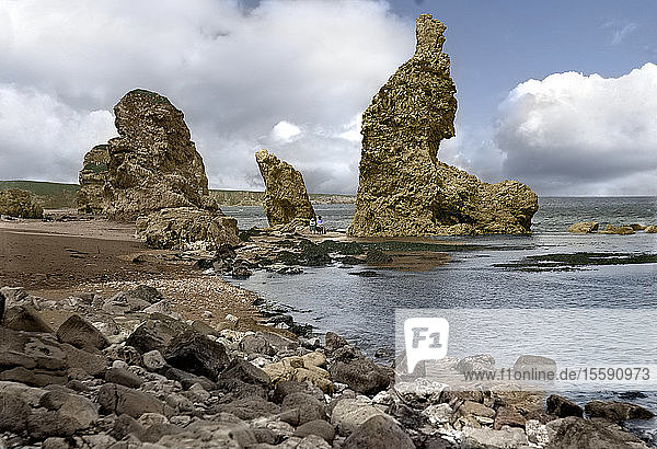 Negative circa 1900  Victorian era. Sea stacks and beach in Marsen Bay with two ladies sitting on rocks  hand coloured photograph; South Shields  Tyne and Wear  England
