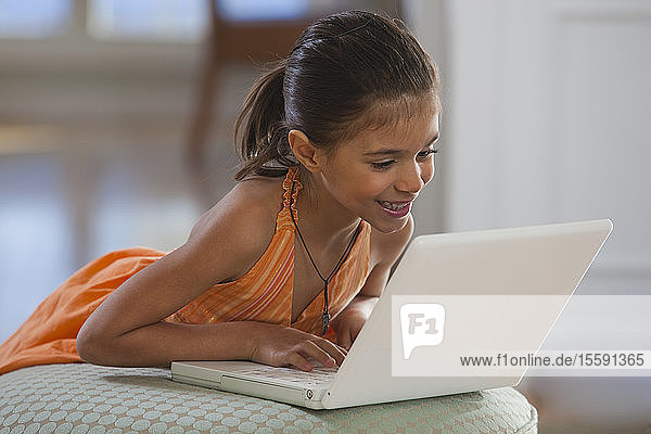 Hispanic girl working on a laptop and smiling