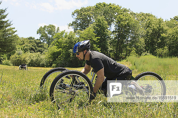 Man with spinal cord injury riding on off-road hand cycle