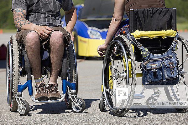 Zwei Behinderten-Autorennen auf Rollstühlen  niedriger Ausschnitt  Auto im Hintergrund
