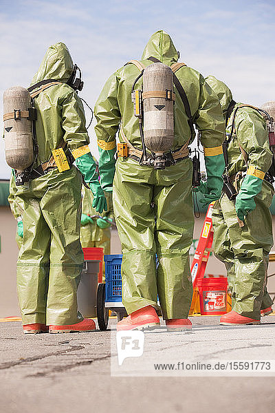 Rückansicht von HazMat-Feuerwehrleuten mit Atemluftflaschen