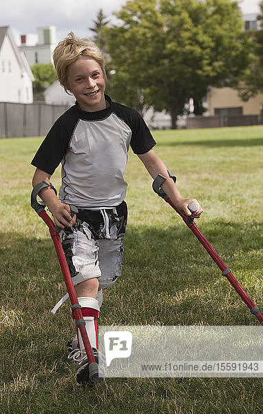 Boy with cerebral palsy walking with the support of crutches