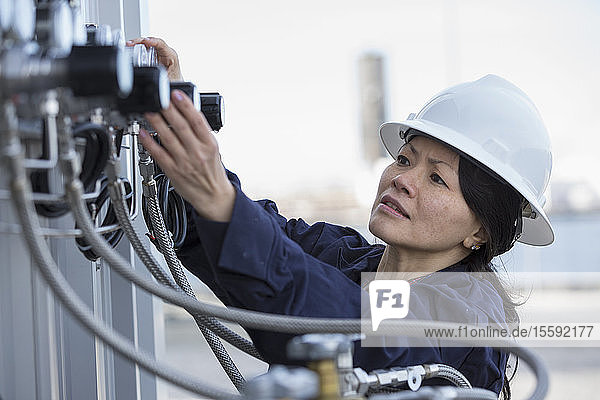 Female power engineer checking transducer at power station