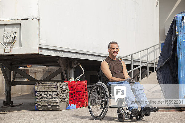 Laderampenarbeiter mit Rückenmarksverletzung im Rollstuhl im Lagerbereich