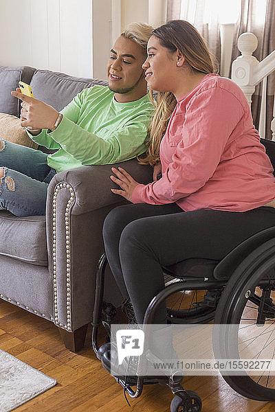 Woman who has Spinal Cord Injury reading a text with her brother