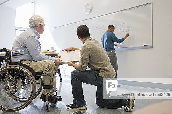 University professor with Muscular Dystrophy teaching his students in a classroom