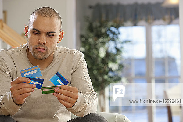 Hispanischer Mann wählt Kreditkarten