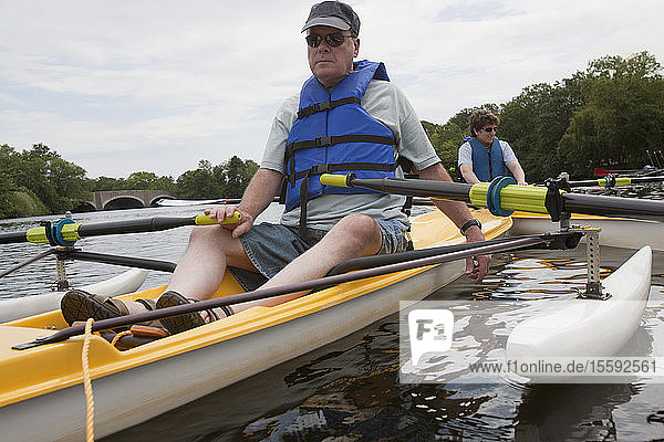 Ein Mann und eine Frau mit Rückenmarksverletzungen sitzen in Booten