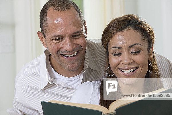 Hispanic couple reading a book
