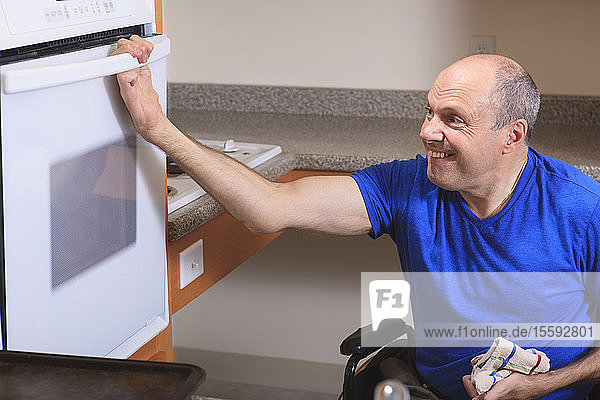 Ein Mann mit Friedreich-Ataxie und deformierten Händen benutzt seinen begehbaren Ofen