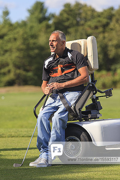 Man with spinal cord injury in an adaptive cart about to play golf