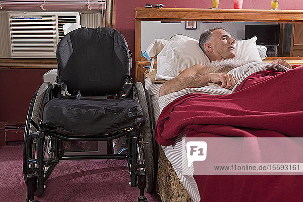 Mann mit Rückenmarksverletzung schläft auf dem Bett