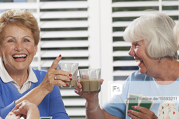 Senior women playing cards and enjoying tea
