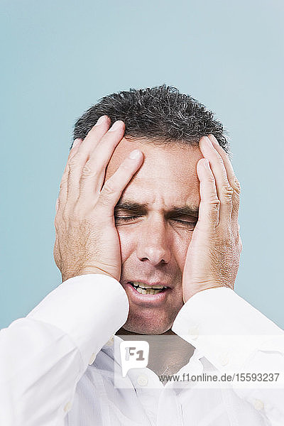 Close-up of a mid adult man suffering from a headache