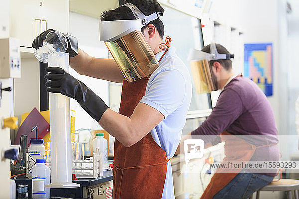 Engineering students wearing protective equipment while working with chemicals in a laboratory
