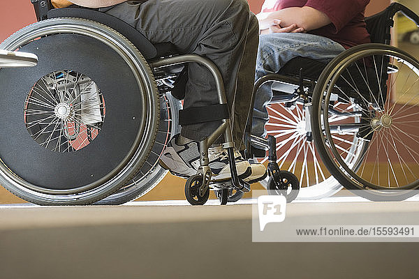 Tiefschnittansicht eines Mannes mit Muskeldystrophie und einer Frau  die in Rollstühlen sitzen