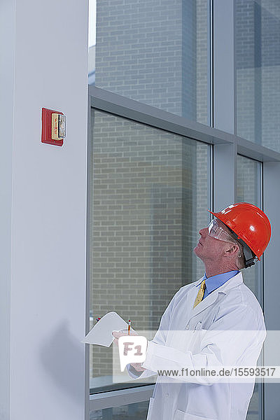 Engineer inspecting fire alarm in a building