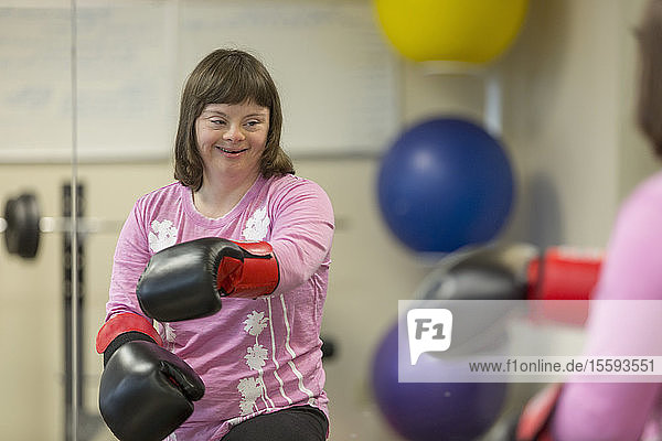 Mädchen mit Down-Syndrom trainiert mit Boxhandschuhen