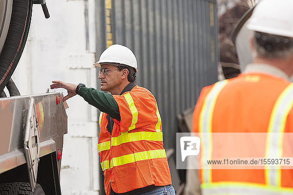 Environmental engineer reaching for log book at tanker truck