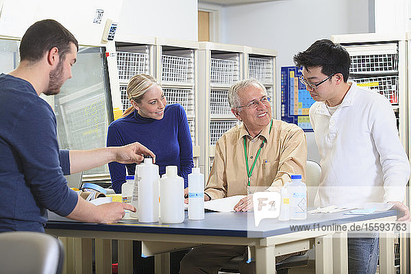 Ingenieurprofessor bei der Besprechung von Lernzielen mit Studenten in einem Chemielabor