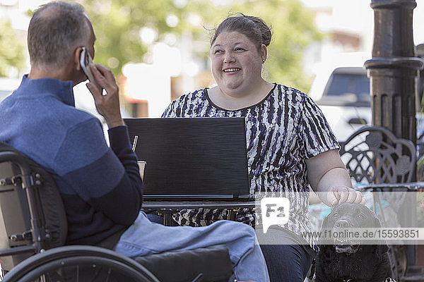 Frau mit Sehbehinderung sitzt mit ihrem Vater in einem Café