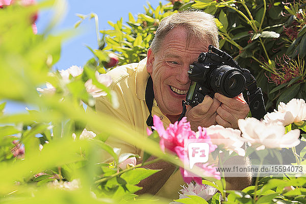 Mann mit zerebraler Lähmung und Legasthenie fotografiert seine Blumen