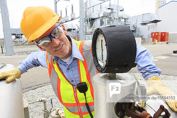 Engineer examining transducer gauge at electric power plant