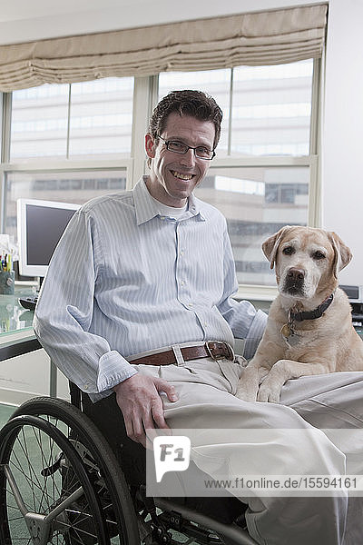 Mann im Rollstuhl mit einer Rückenmarksverletzung und einem Diensthund