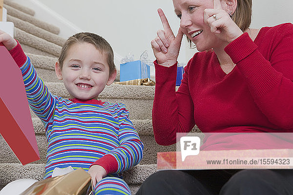 Frau gebärdet das Wort Surprise in amerikanischer Gebärdensprache  während sie mit ihrem Sohn kommuniziert