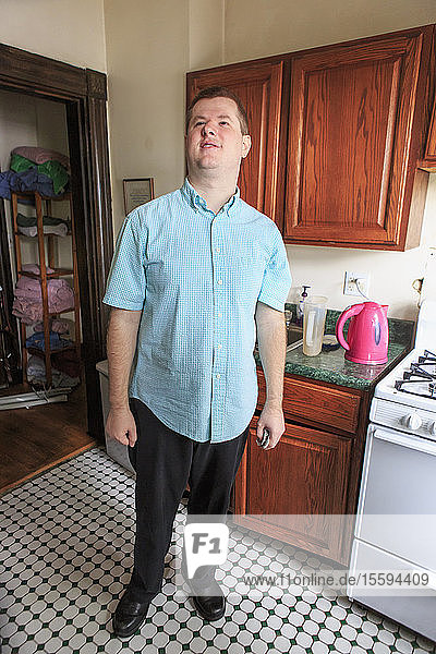 Mann mit Sehbehinderung steht in seiner Wohnung