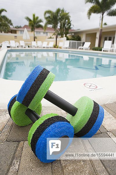 Close-up of two hand weights at the poolside