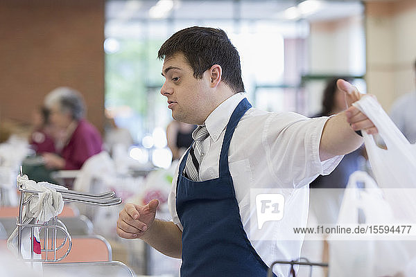 Mann mit Down-Syndrom arbeitet in einem Lebensmittelladen