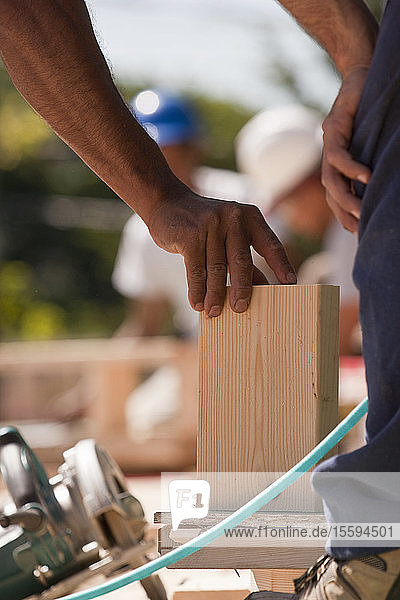 Zimmerleute beim Anbringen von Holzverkleidungen auf einer Baustelle