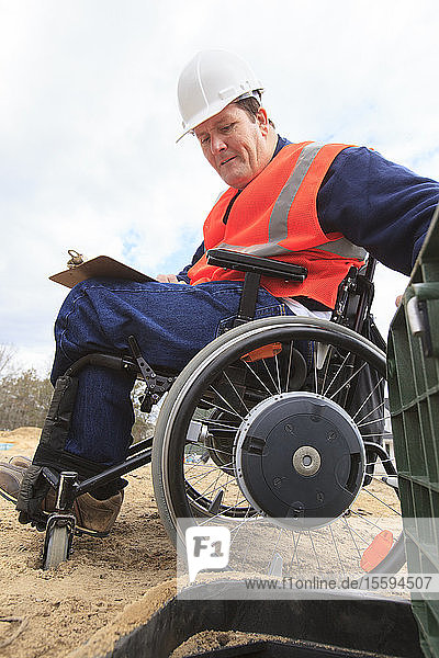 Construction engineer with spinal cord injury inspecting utility box
